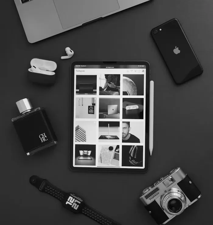 A phone, camera and notebook on a dark desk